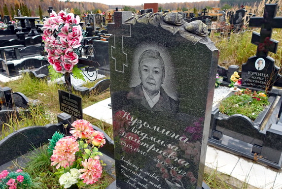 Памятник из чёрного гранита с вырезанными розами в верхней части